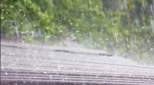 Closeup of roof with hail falling on it